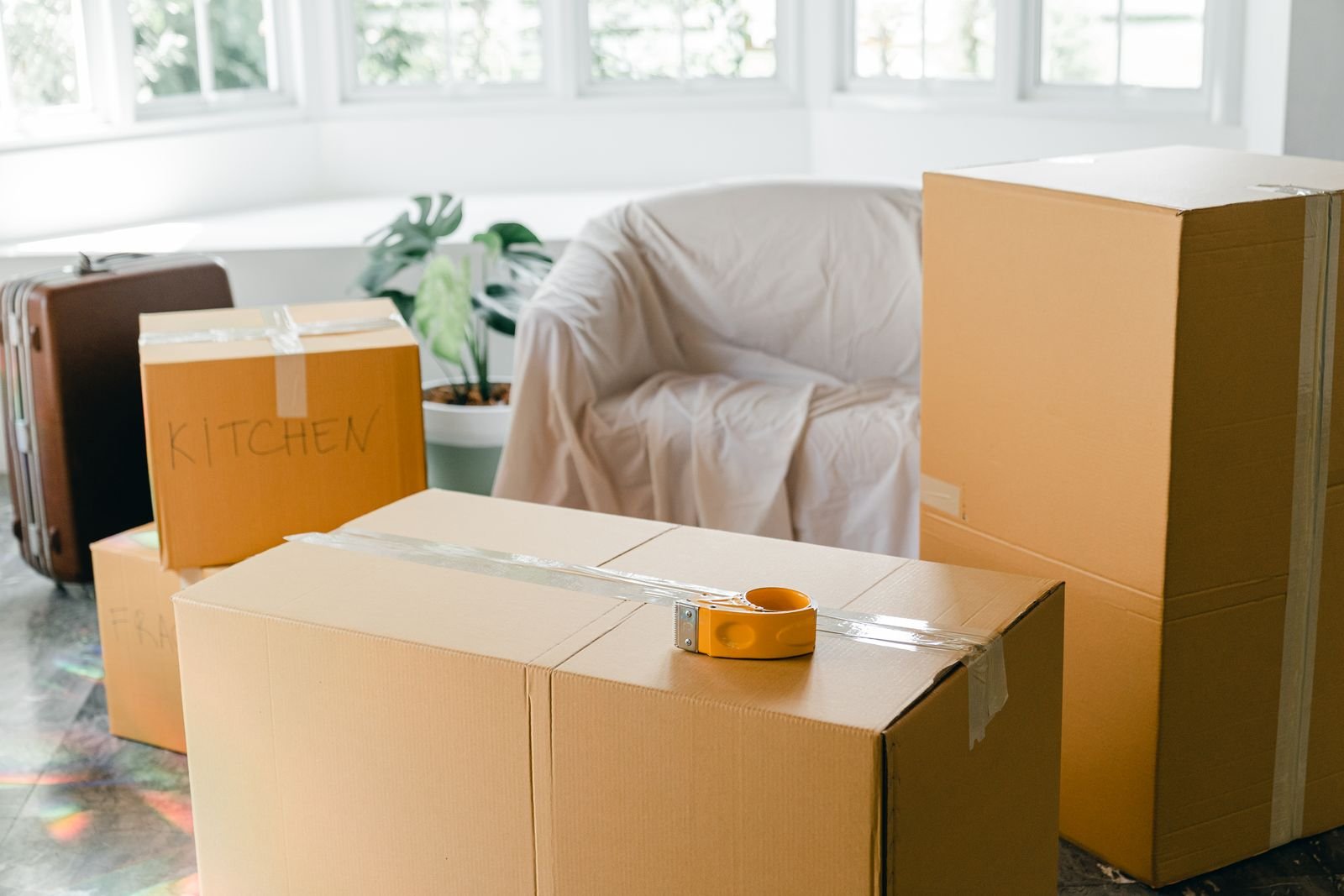 Appartement en cours de débarras Cartons empilés dans un séjour vidé, prêts à être évacués